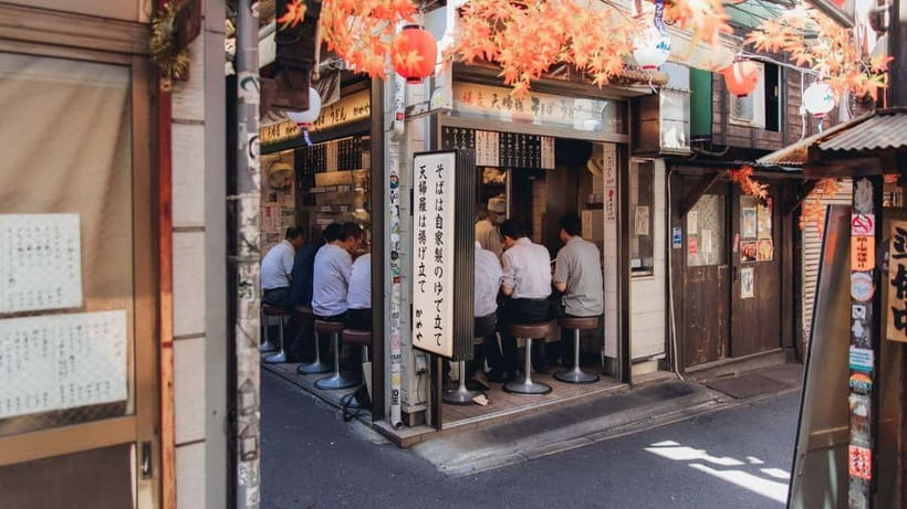 Tokyo After 5: Local Eats, Drinks & Culture Walk - Tsukishima Monja Town: cooking monja-yaki on a hotplate